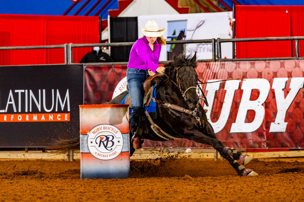 Chloe Gray turns a barrel on her black horse Scratchin At Heaven