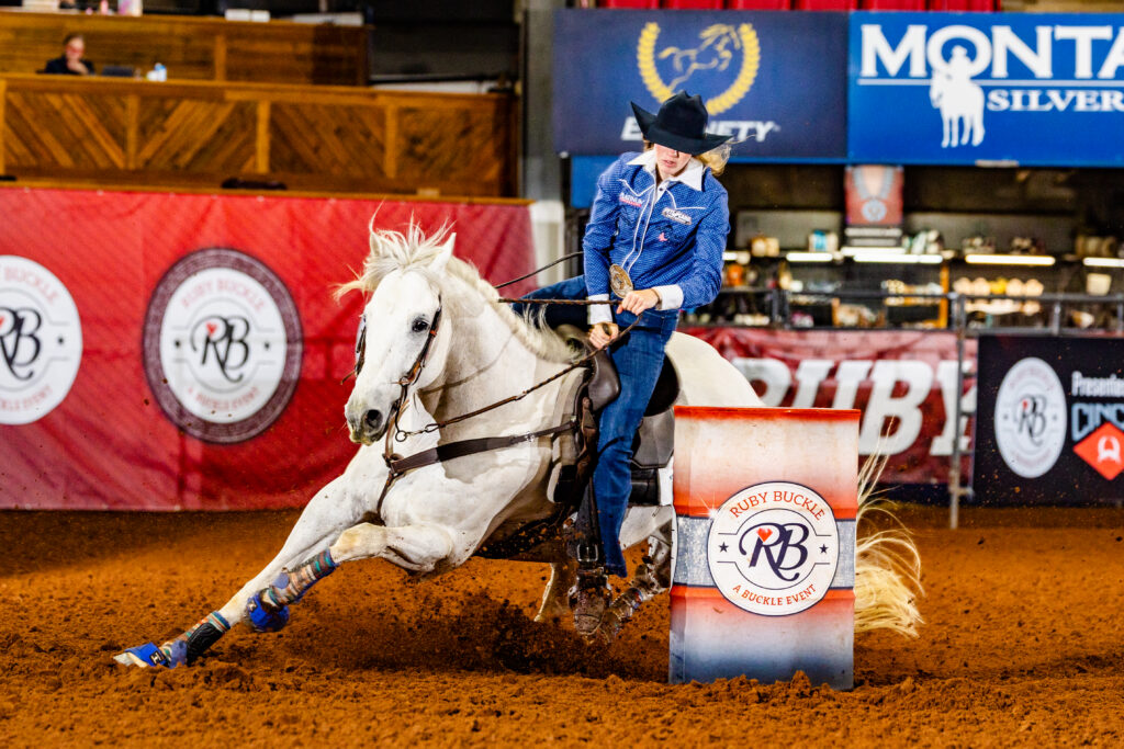 Morgan Bagnell turns a barrel on a white horse