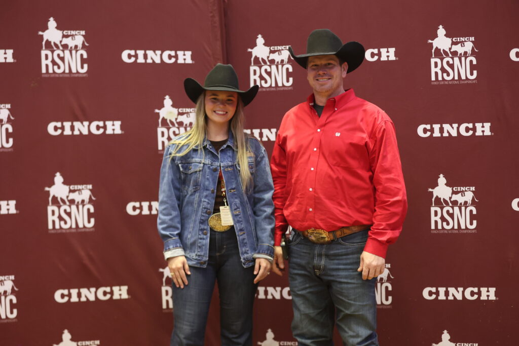 Two cowboy-hatted competitors, one wearing a gold trophy buckle, pose in front of a Cinch RSNC backdrop