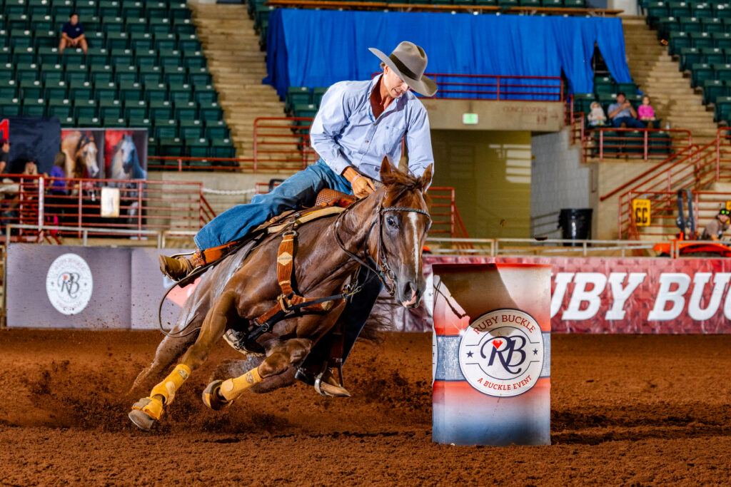 A man on a horse turning a barrel