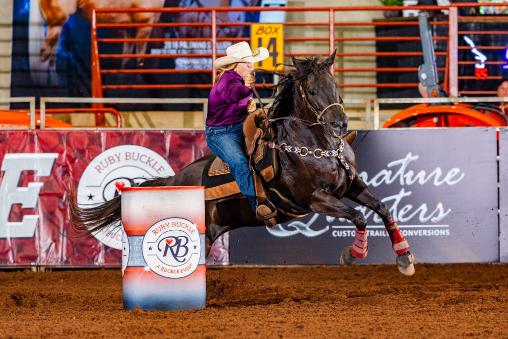 Chloe Gray leaves a barrel on a black horse