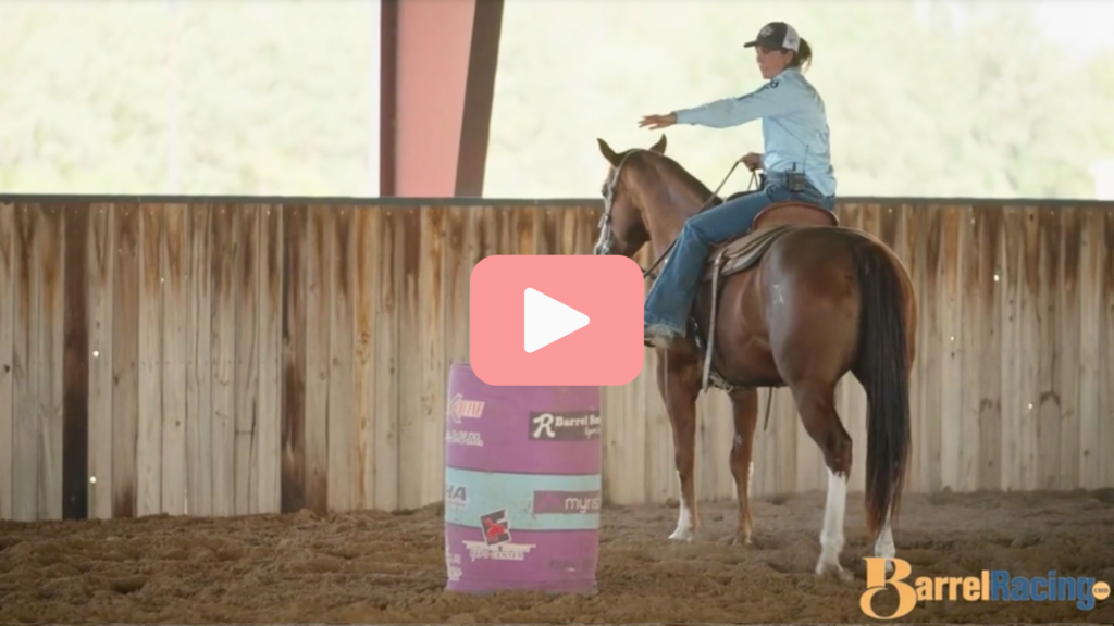 Ryann Pedone points to a barrel while sitting on her horse