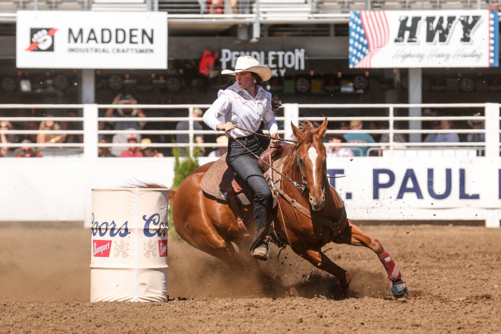 Anneliese Mccurry turns a barrel on her red horse