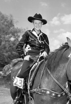 a woman in a cowboy hat sits atop a horse black and white photo