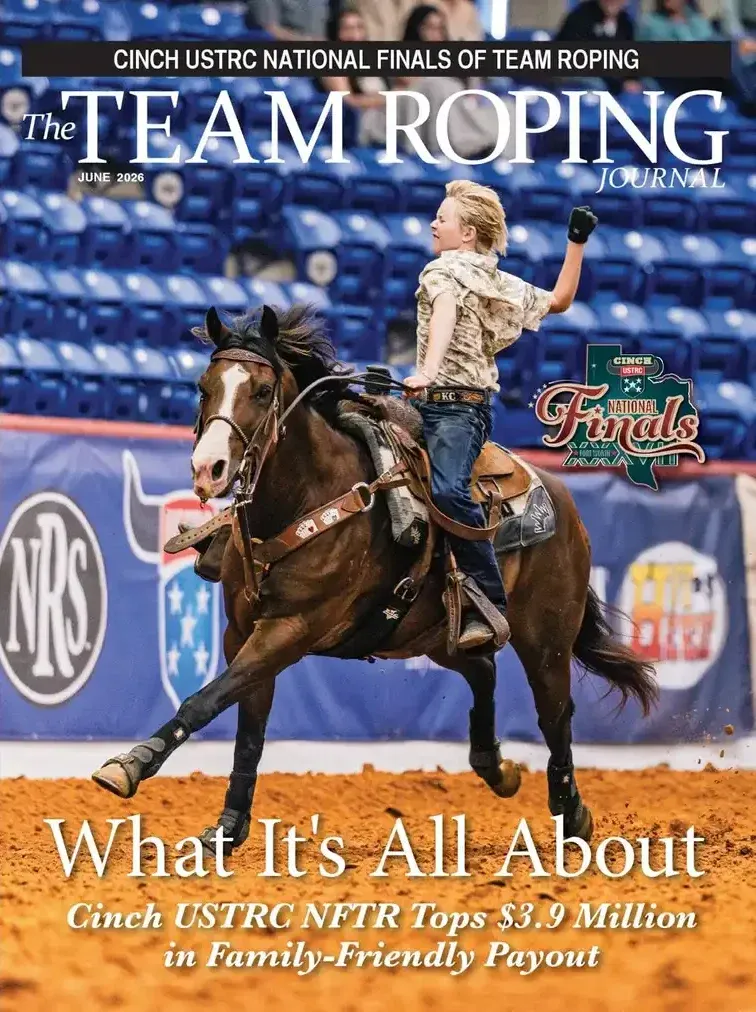 Team roper on horseback raises fist in celebration during Cinch USTRC National Finals of Team Roping competition