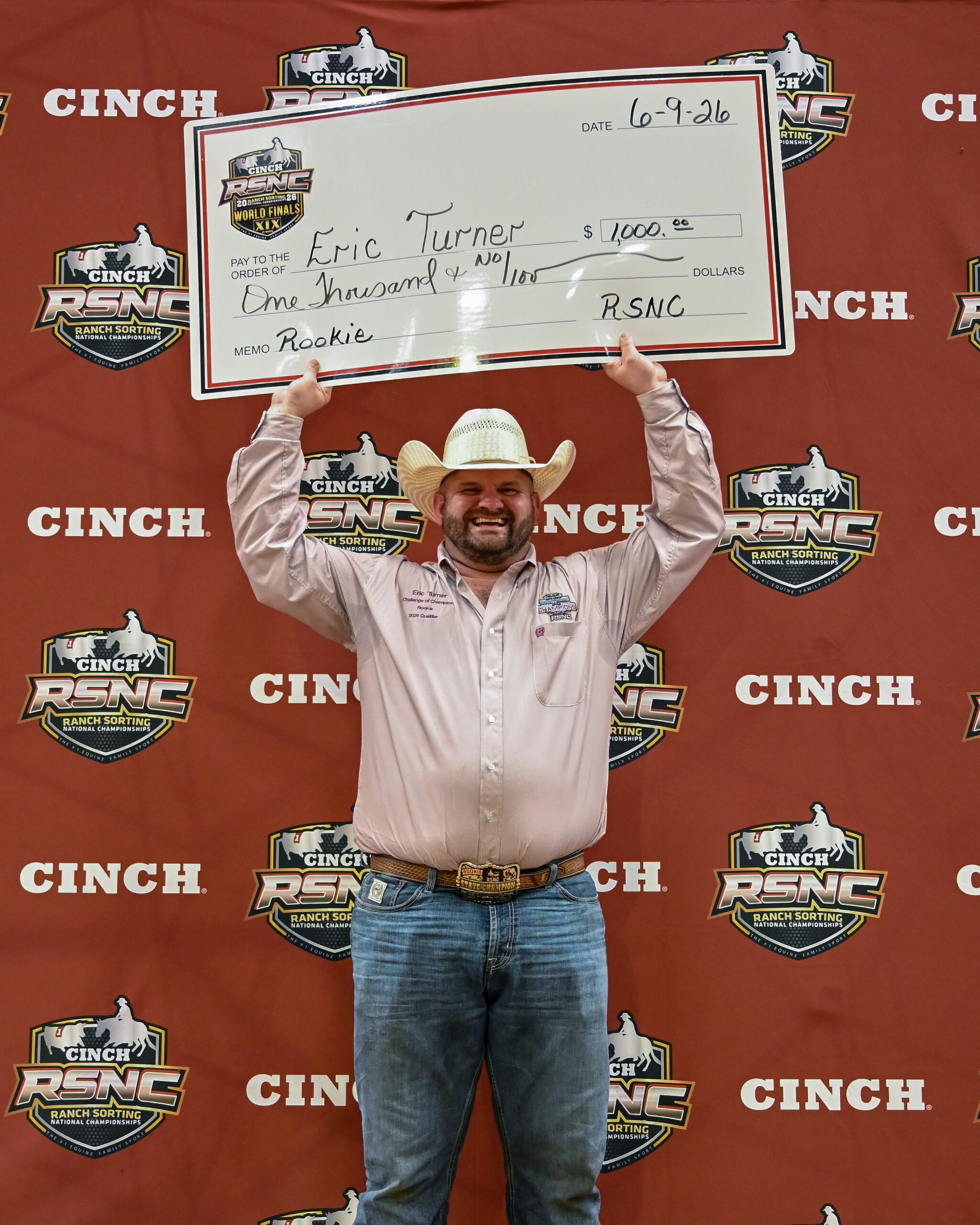 Winner holds oversized check for $7,000 at Cinch RSNC Ranch Sorting National Championships event