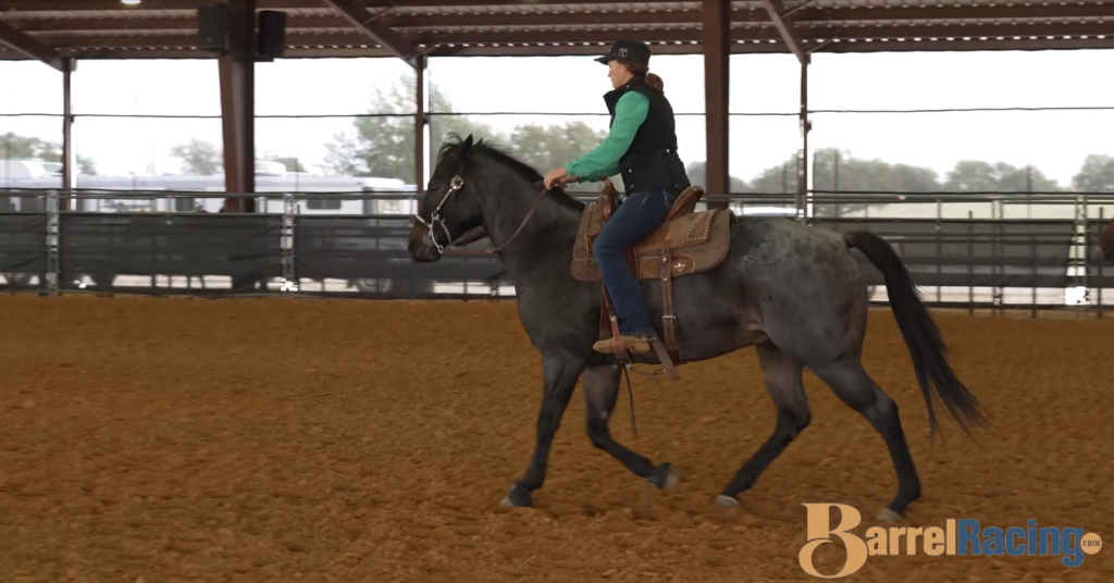Jordon Briggs riding a horse in an indoor arena.