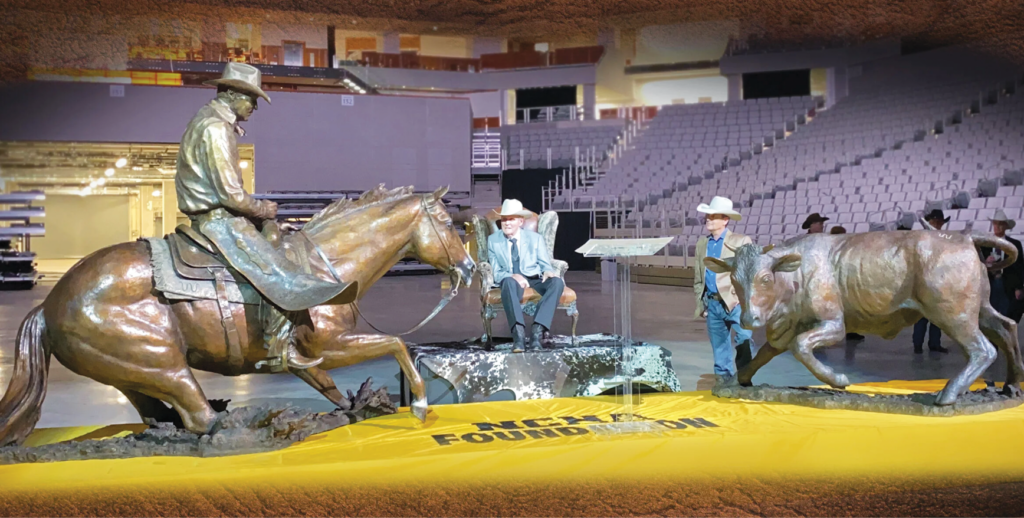 Bronze statue of a cutting horse and rider working a steer unveiled in an arena with a yellow NCHA Foundation banner