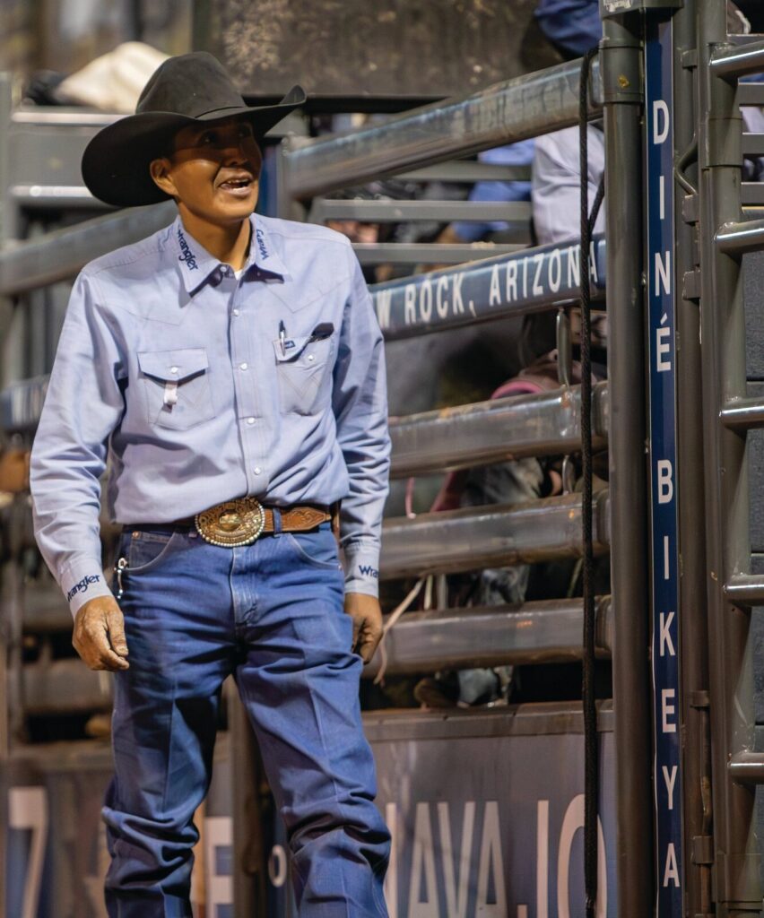 Derrick Begay walking near the bucking chutes at the Home of the Navajo PRCA Rodeo