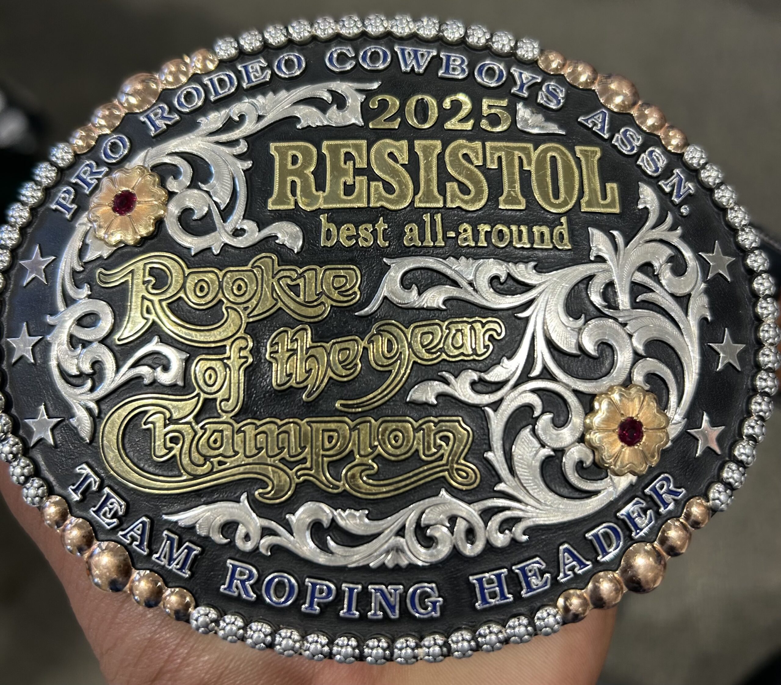2025 Pro Rodeo Cowboys Association Resistol Best All-Around Rookie of the Year Champion belt buckle with ornate silver scrollwork, gold lettering, and jeweled border