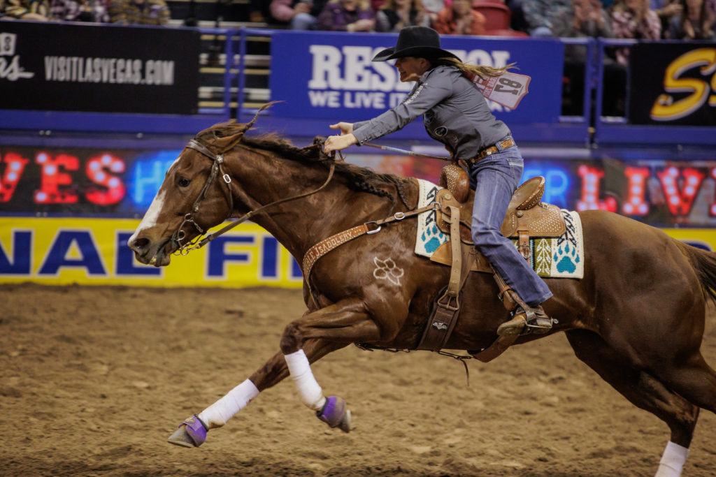 Brittany Pozzi and Katniss runs out of the arena during a barrel racing run at NFR.