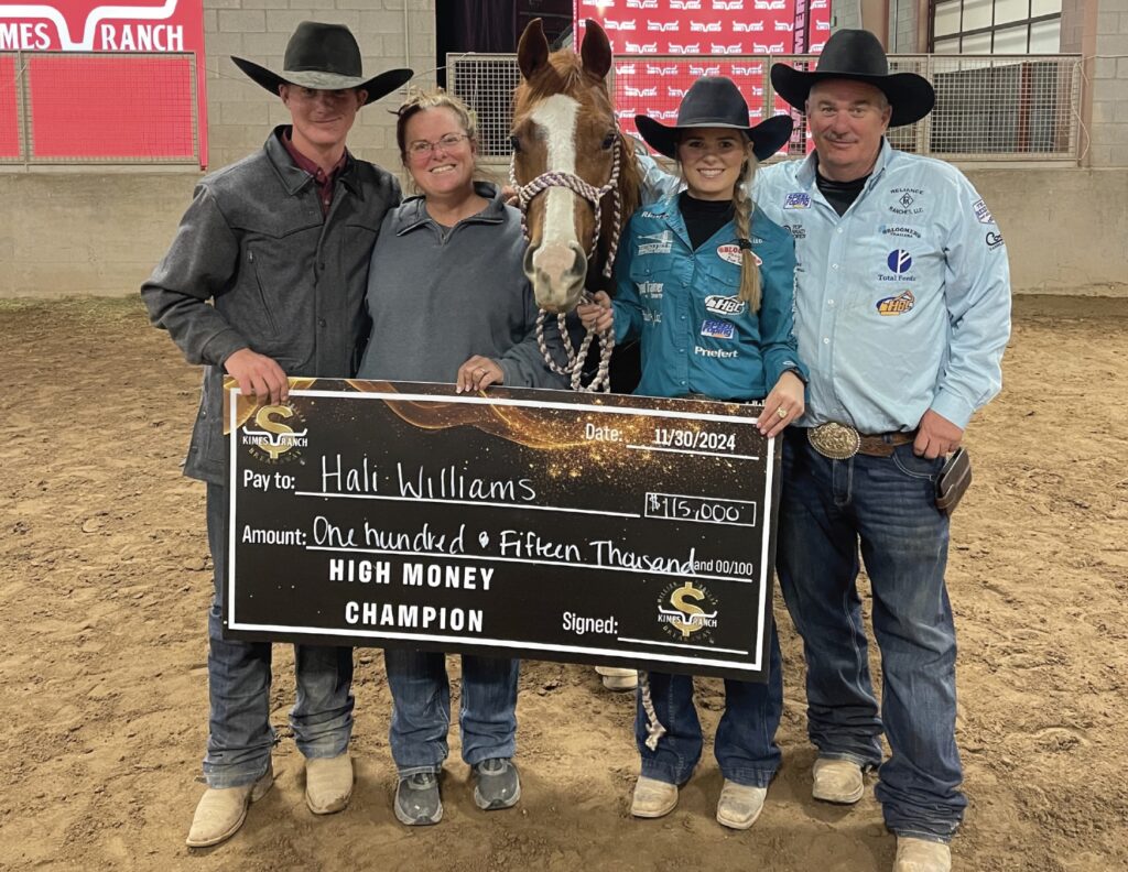 Four people and a sorrel horse pose in an arena with an oversized $115,000 High Money Champion check