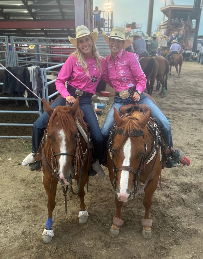 Sarah and Martha Angelone smile at the camera while on horseback