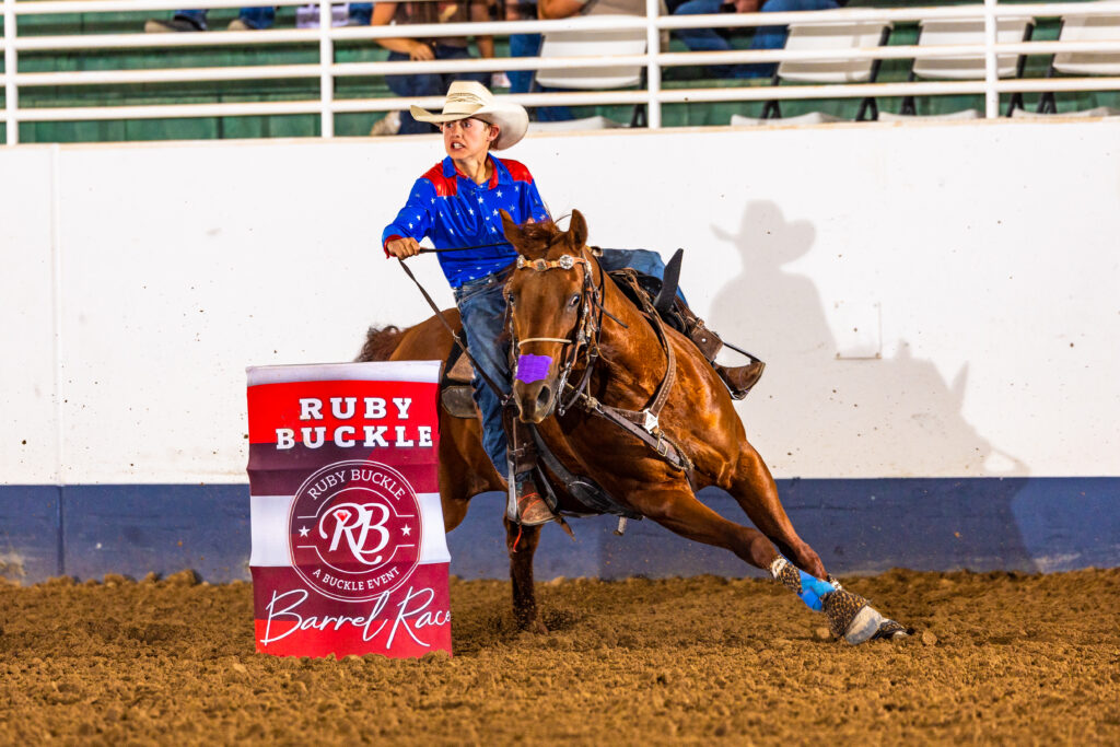 Young boy Lincoln turns a barrel in a cowboy hat on his barrel horse