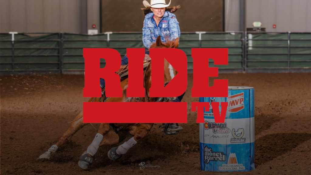 Barrel racer in a blue shirt and white cowboy hat rounds a sponsor-covered barrel in an indoor arena, with the RIDE TV logo overlaid