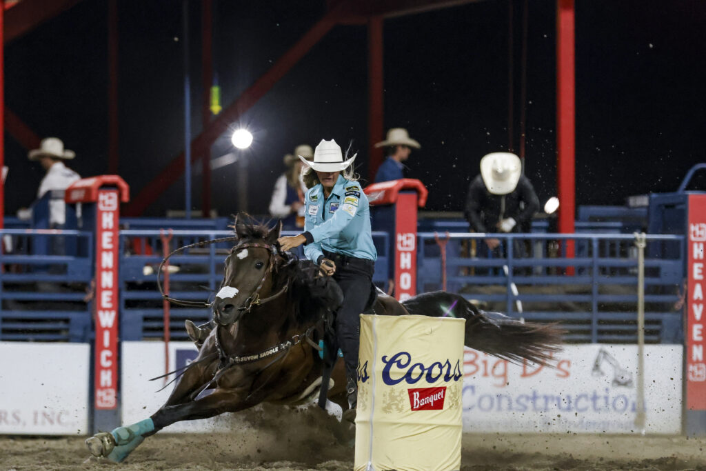Michelle Alley turns a barrel on her small dark mare